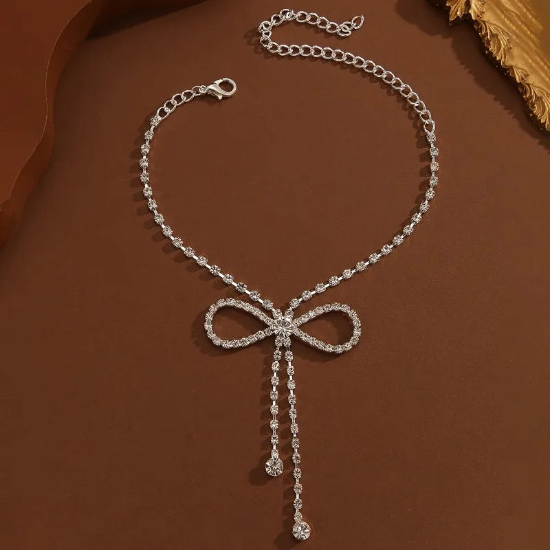 Bracelet de cheville de luxe orné de zirconiums scintillants et d'un ruban à pompon - Accessoire de cheville délicat pour femme