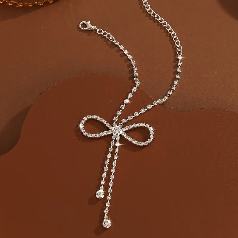 Bracelet de cheville de luxe orné de zirconiums scintillants et d'un ruban à pompon - Accessoire de cheville délicat pour femme